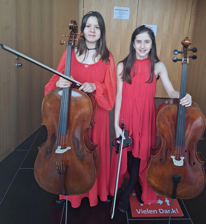 die Schülerinnen Lena Pontes und Matilde Botti mit ihren Celli vor dem wertungsraum bei Jugend Musiziert Wettbewerb
